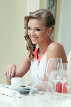 Cheerful attractive woman posing at table in restaurant