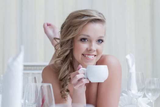 Lovely young woman posing with cup of coffee, close-up