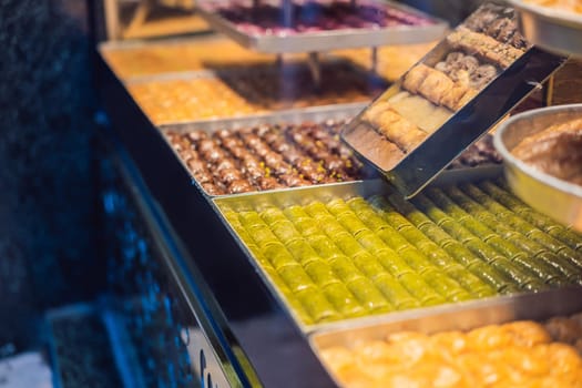 Traditional oriental sweet pastry cookies, nuts, dried fruits, pastilles, marmalade, Turkish desert with sugar, honey and pistachio, in display at a street food market.