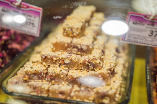 Traditional oriental sweet pastry cookies, nuts, dried fruits, pastilles, marmalade, Turkish desert with sugar, honey and pistachio, in display at a street food market.