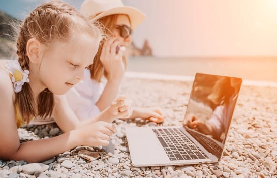 Woman sea laptop. Business woman in yellow hat working on laptop by sea. Close up on hands of pretty lady typing on computer outdoors summer day. Freelance, digital nomad, travel and holidays concept.