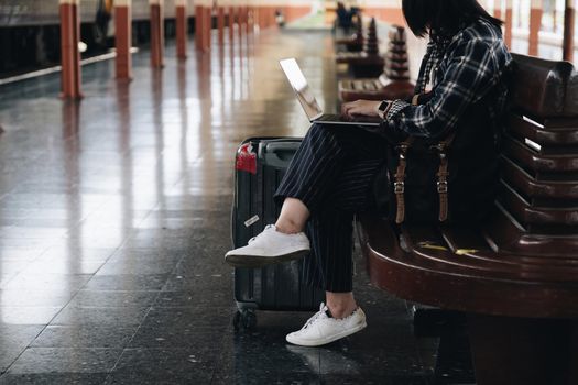 Image of Young freelance working at train station before travel. work and travel concept