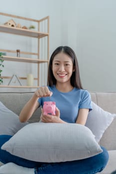 Asian young woman holding a piggy bank and coin, Savings concepts
