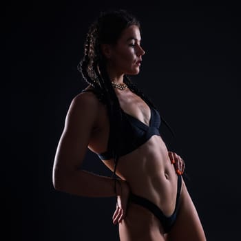 Perfect woman body on a black background studio, sport muscles belly