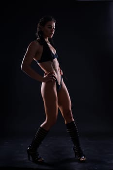 Perfect woman body on a black background studio, sport muscles belly