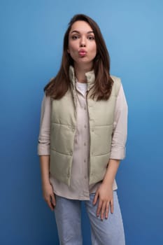pretty european brunette young woman in vest and shirt on studio background.