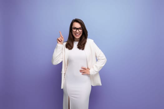 smart woman with thick dark hair in white outfit on studio background.