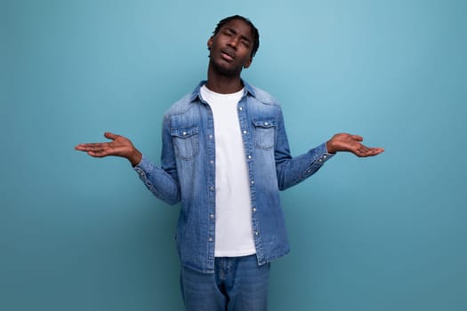 sad african man with dreadlocks in a denim jacket.