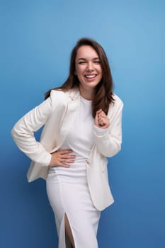 positive energetic young brunette with long hair woman in white dress with hollywood smile.