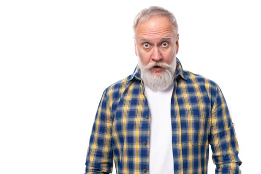 surprised mature gray-haired man with a beard in a shirt on a white background.