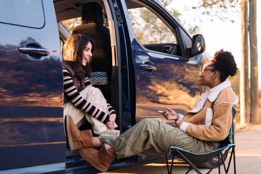 two young friends chatting happy in camper van, concept of travel adventure and weekend getaway with best friend