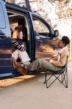 two young friends chatting happy in camper van, concept of travel adventure and weekend getaway with best friend