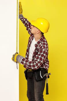 professional builder in work clothes, helmet taking measurements of wall, house renovation repair concept.