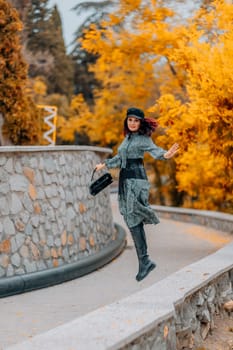 A woman walks outdoors in autumn, enjoys the autumn weather