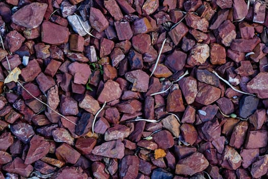 Red pebbles close-up mulching beds. Landscaping of parks. Small faction.