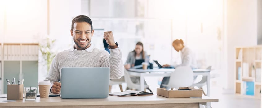 Man, laptop and celebrate at office desk for success, deal or crypto on internet at startup. Winner businessman, computer or smile for winning celebration, bitcoin goal and stock market achievement.