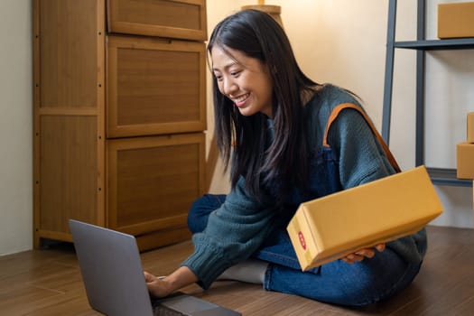 Young happy Asian woman looking at laptop screen, celebrate for sell, smile young entrepreneur happy for sale successful . High quality photo