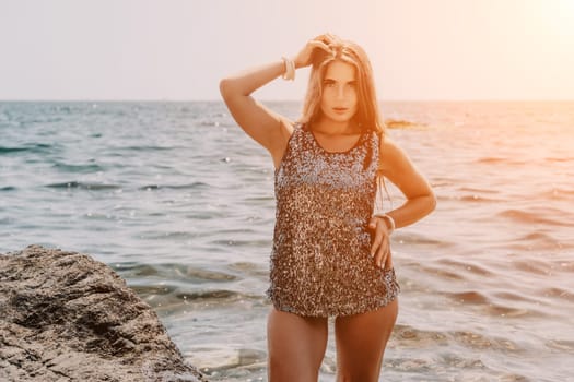 Woman travel sea. Young Happy woman in a long red dress posing on a beach near the sea on background of volcanic rocks, like in Iceland, sharing travel adventure journey