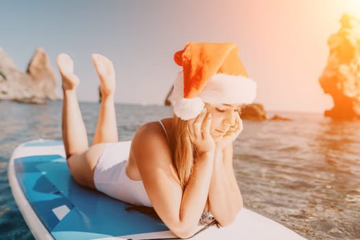 Close up shot of happy young caucasian woman looking at camera and smiling. Cute woman portrait in bikini posing on a volcanic rock high above the sea