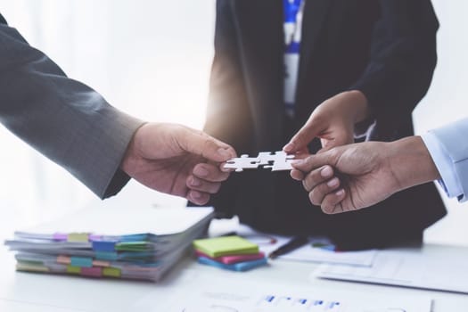 Group of business people putting their hands working together on wooden background in office. group support teamwork agreement concept.