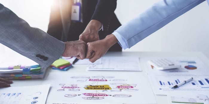 Group of business people putting their hands working together on wooden background in office. group support teamwork agreement concept.