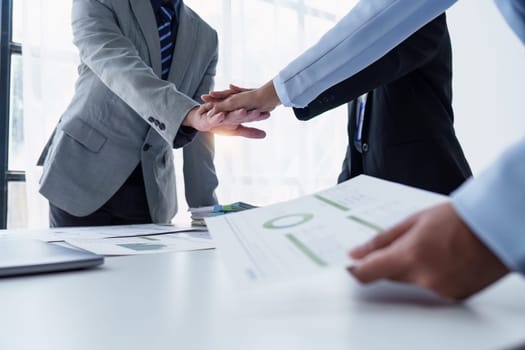 Group of business people putting their hands working together on wooden background in office. group support teamwork agreement concept.