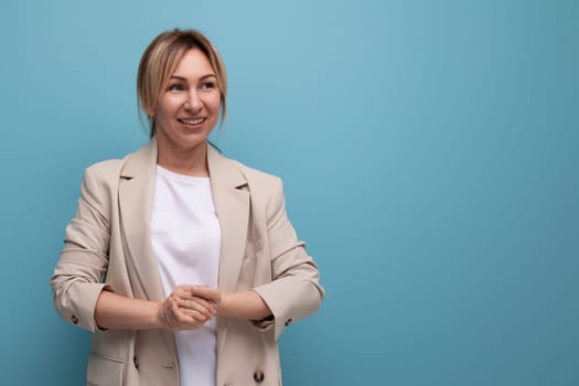 close-up of a positive smiling blonde business woman in a jacket successful in work on the background with copy space.