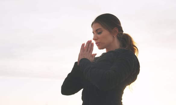 Yoga first, everything else can wait. a woman practising yoga on the promenade