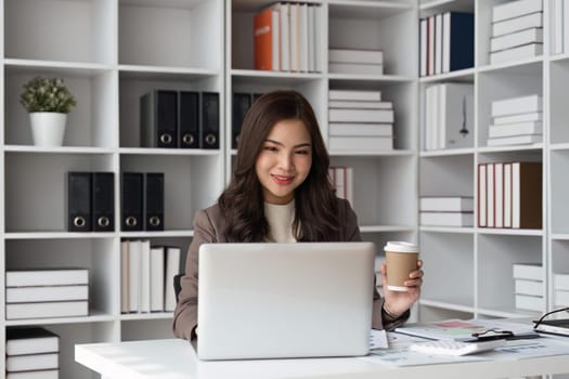 business woman working with laptop in office and drink coffee, business financial concept.