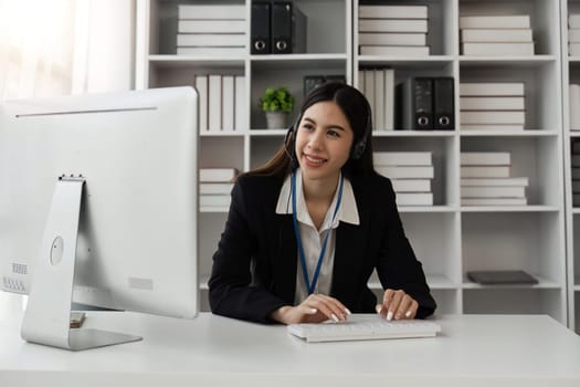 Smiling young female call center worker with headphones.