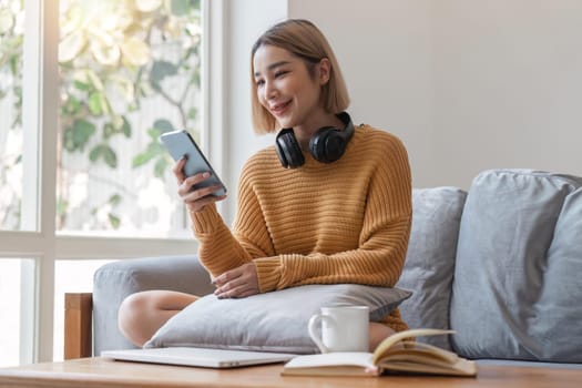 Happy asian woman pretty girl relaxing at home, resting, typing on smartphone, using online app, software, shopping on Internet, making video call. Mobile phone communication.