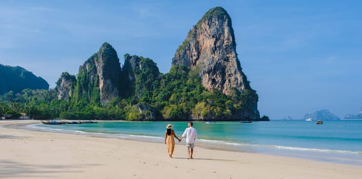 Railay Beach Krabi Thailand, the tropical beach of Railay Krabi, a couple of men and women on the beach, Panoramic view of idyllic Railay Beach in Thailand with a traditional long boat.
