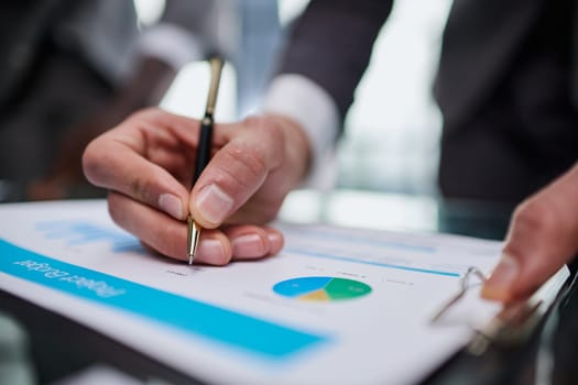 Businessman takes a notes on the sheets of diagram on the desk