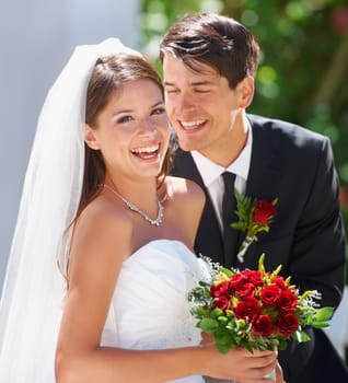 Whispering sweet nothings. Two delighted newlyweds celebrating outdoors together