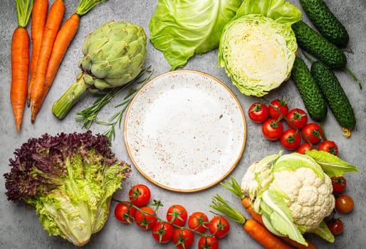 Assorted food raw products: vegetables, beef meat, fish salmon and empty plate in centre, light rustic stone table top view copy space. Healthy food background, ingredients for balanced diet.