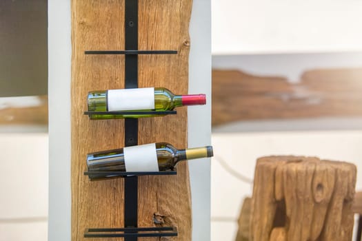 Wine storage holder made of wood and metal rustic style. Wine bottles are arranged on a holder with copy space. The concept of collecting alcoholic beverages. High quality photo