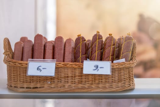 Different sausages lies in a basket. Sausages are made from meat. High quality photo