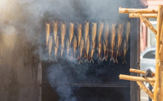 Hot smoked sturgeon. A whole hot-smoked sturgeon lies in the smoking shop. The process of smoking exotic fish. High quality photo