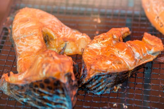 Hot smoked salmon. Large pieces of Atlantic salmon are smoked on a smokehouse grate close-up. Fish smoking plant. High quality photo