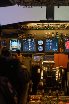 A man is studying to be a pilot in a flight simulator. Close-up of male hands navigating an aircraft