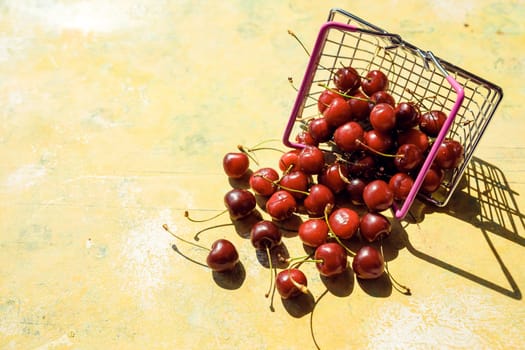 Fresh red fruit and berries - cherries, peaches and strawberries - in supermarket cart tray on black background. Copy space