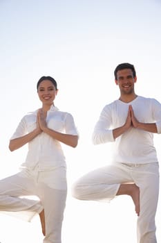 Yoga stances that improve balance. a young man and woman doing yoga outdoors
