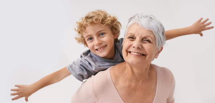 Airplane, smile and portrait of grandmother with child embrace, happy and bond on wall background. Love, face and senior woman with grandchild having fun playing, piggyback and enjoying game together.
