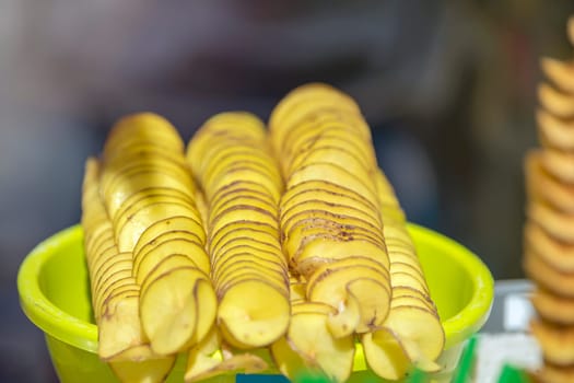 The process of making potato chips at home. Potato finely chopped into thin slices for further frying in sunflower oil. Organic potato chips