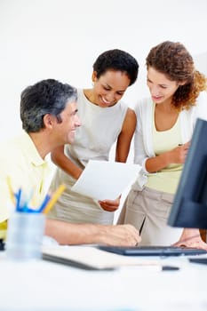 Business people taking a look at paperwork. Smiling business people at work with woman holding paperwork