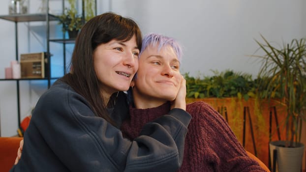 Happy two lesbian women family couple or girls friends smiling friendly, glad expression looking away, relaxation feel satisfied, good news, positive pregnancy test at home. LGBT people IVF maternity