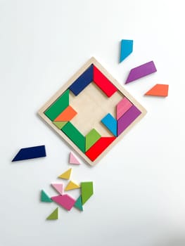 tangram game. Multicolored parts are disassembled on white table. top view on white background. High quality photo