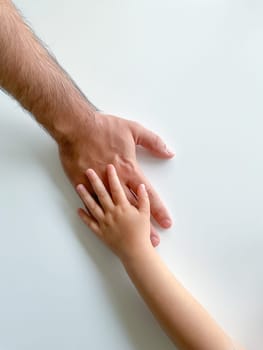 Adult and child hold their hands together. Fathers Day. A child gives a hand to an adult. Postcard concept