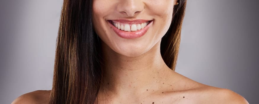 Dental, care and woman with a smile for teeth, healthcare and the dentist against a grey studio background. Happy, excited and girl model with medical cosmetics for cleaning of mouth for wellness.