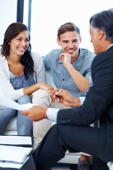 Couple discussing financial plans with advisor. Mature advisor explaining financial plan to couple at home
